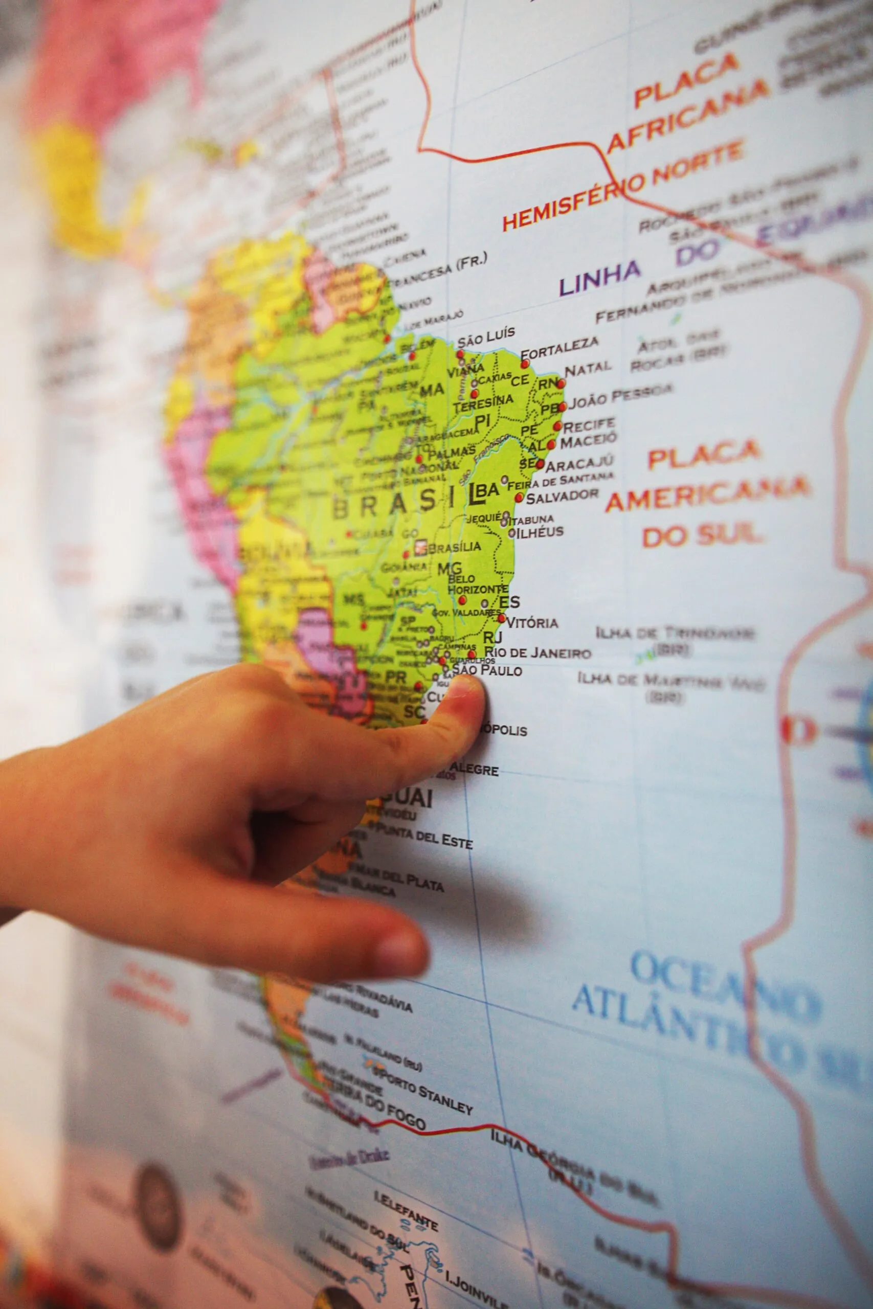 Dito che indica il Brasile su una mappa